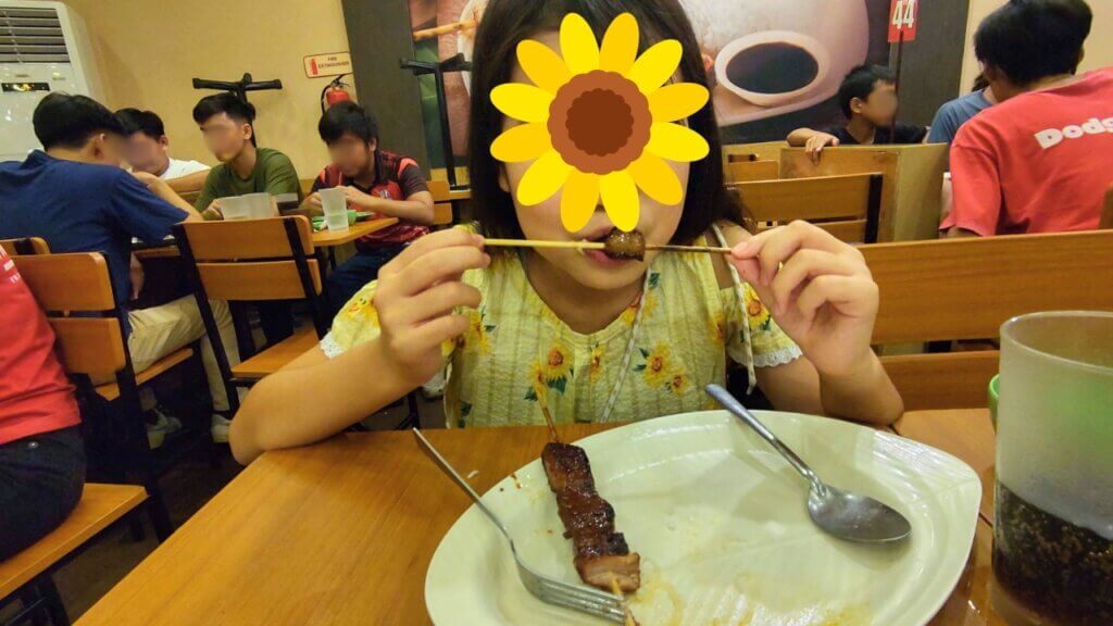 フィリピンで有名なファーストフードチェーン、マグイナサル。豚肉を食べる娘。